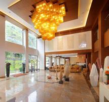 Luxury lobby with golden chandelier, marble floors, and mountain views through floor-to-ceiling windows