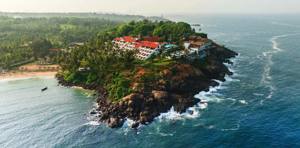 Cliffside resort with red-roofed buildings overlooking Arabian Sea and tropical coastline