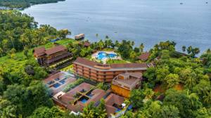 Aerial view of backwater resort with pool, lush gardens, palm trees, and serene waterway