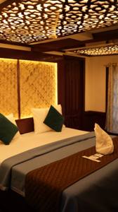 Bedroom with a grey bedspread under a carved lattice ceiling