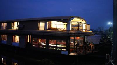 Grand Nirvana houseboat lit up at dusk